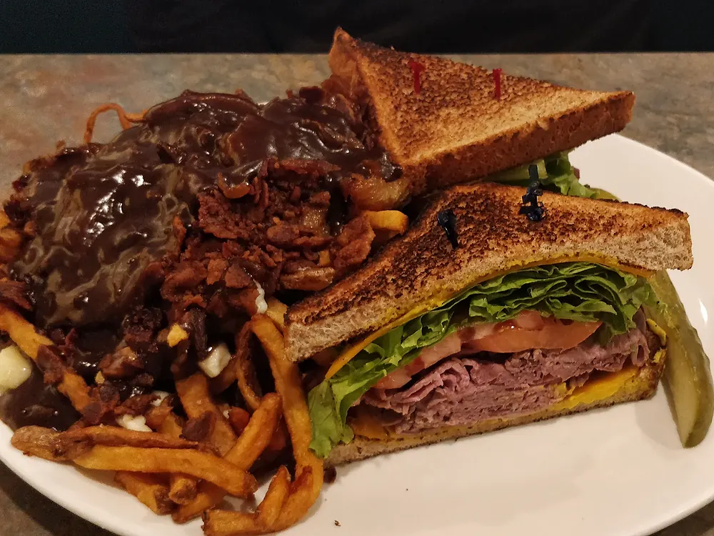 Roast beef sandwich on toast with a side of poutine